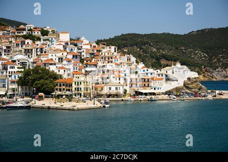 Die historische Stadt auf der Insel Skopelos vom Boot aus gesehen, wenn man im Sommerlicht in den Hafen einfährt. Stockfoto