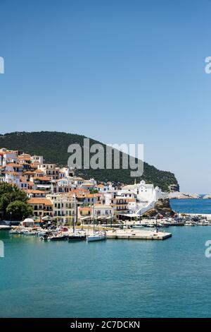 Die historische Stadt auf der Insel Skopelos vom Boot aus gesehen, wenn man im Sommerlicht in den Hafen einfährt. Stockfoto