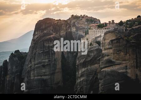 Die Meteora Klöster mit ihrer landschaftlichen Lage auf den Felsen in Griechenland mit Sonnenuntergang Stockfoto