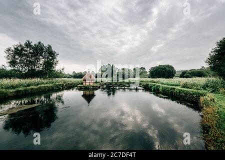 Aalfallen und eine kleine reetgedeckte Fischerhütte am Fluss Test, in der Nähe von Longstock Village, Hampshire (Hants), England, Großbritannien Stockfoto