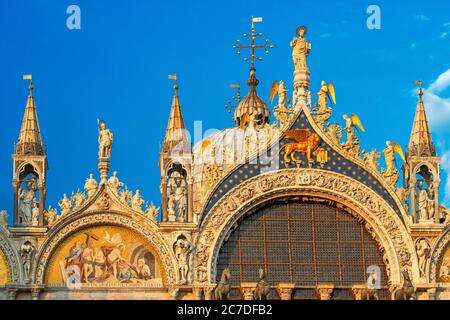 Basilica San Marco spiegelt sich in Acqua alta auf dem Piazza San Marco in der Dämmerung während Sonnenuntergang, Venedig, Italien mit Bewegung verschwimmen auf die Massen von Touristen Stockfoto