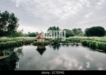 Aalfallen und eine kleine reetgedeckte Fischerhütte am Fluss Test, in der Nähe von Longstock Village, Hampshire (Hants), England, Großbritannien Stockfoto