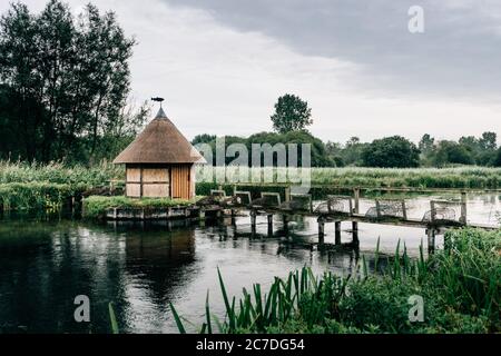 Aalfallen und eine kleine reetgedeckte Fischerhütte am Fluss Test, in der Nähe von Longstock Village, Hampshire (Hants), England, Großbritannien Stockfoto