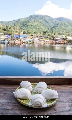 Gedämpftes Brötchen im traditionellen chinesischen Stil (Mantou) serviert auf der Holzbar in der Nähe des kleinen Stausees des chinesischen Restaurants.das Hotel liegt im valle Stockfoto