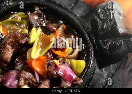 High-Angle Nahaufnahme von leckeren Rindfleisch Bourguignon mit Gemüse In einem schwarzen Topf Stockfoto