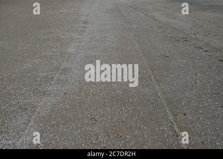 Spuren von Autoreifen am Sandstrand am Meer. Sommer. Stockfoto