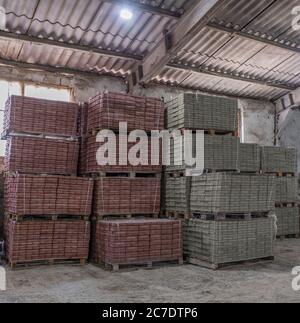 Pflasterplatten. Kisten aus Pflasterplatten auf Holzpaletten. Herstellung von Pflasterplatten. Stockfoto