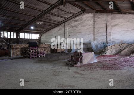 Sand und Farbe für Pflasterplatten sind auf dem Boden in der Pflastersteinproduktionswerkstatt verstreut. Stockfoto