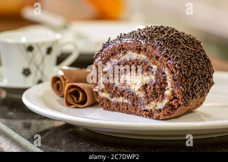 Auf dem Tisch wird ein Stück Schokoladenroulade serviert. Gastronomie. Stockfoto