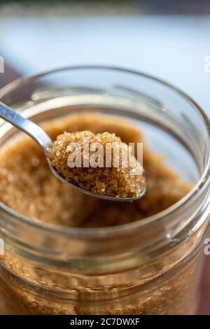 Löffel braunen Bio-Zucker in Glas Zucker Schüssel. Stockfoto