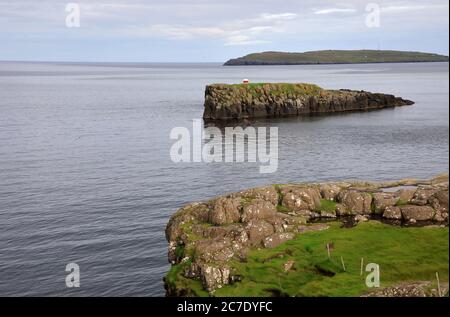 Der Blick auf Hoyviksholmur Insel und Nolsoy Insel in der Ferne mit Schafen in Küstenklippe im Vordergrund.Torshavn. Streymoy.Färöer-Inseln.Territorium von Dänemark Stockfoto