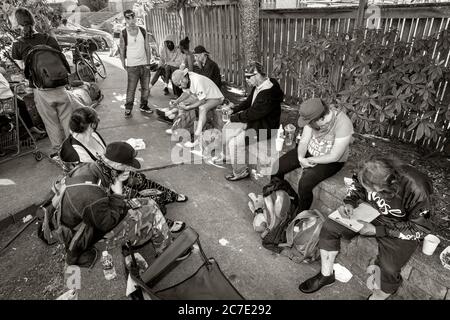 Everett, Washington, USA. Juli 2020. Ohne offizielles Lager für Obdachlose verbringen sie ihre Tage in Everett Stadtparks wie diesem, Mathew Parsons Park, bis die Sonne untergeht, wenn sie sich zerstreuen, um einen sicheren Ort zu finden, um die Nacht zu verbringen. Der Mann unten rechts füllt einen Antrag aus, um einen Hotelgutschein zu bekommen. Dies ist der erste Schritt, um von der Straße zu kommen. Es bietet einen sauberen und sicheren Ort für ein paar Tage. Quelle: Tom Kirkendall/ZUMA Wire/Alamy Live News Stockfoto