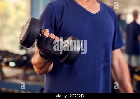 Ein Porträt von kahlen älteren Mann im Turnhalle Training mit Hanteln. Menschen, Gesundheit und Lifestyle-Konzept Stockfoto