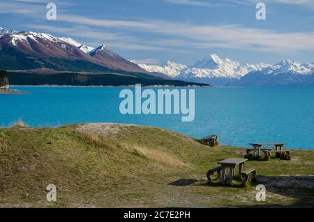 Fernansicht des Mount Cook über den Lake Pukaki, Südinsel, Neuseeland mit Bänken im Vordergrund Stockfoto