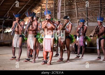 Indigene Männer blasen auf einem traditionellen Instrument Stockfoto