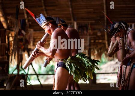 Indigene Männer blasen auf einem traditionellen Instrument Stockfoto