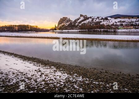 Schneebedeckte Ruinen der Burg Devin über der Donau in Bratislava, Slowakei bei Sonnenaufgang Stockfoto