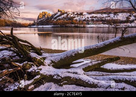 Schneebedeckte Ruinen der Burg Devin über der Donau in Bratislava, Slowakei bei Sonnenaufgang Stockfoto