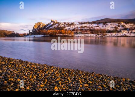 Schneebedeckte Ruinen der Burg Devin über der Donau in Bratislava, Slowakei bei Sonnenaufgang Stockfoto