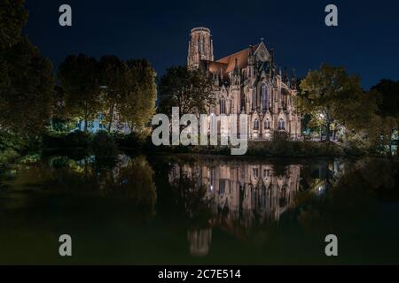 Nachtaufnahme der evangelischen Kirche Johanneskirche in der Nähe eines Sees in Stuttgart Stockfoto