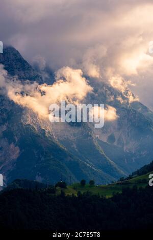Vertikale Aufnahme von schönen Bergen in dicken Wolken und bedeckt Grüne Täler Stockfoto