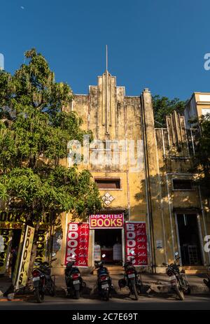 Pondicherry, Indien - Februar 2020: Ein altes, verblassenes, gelbes französisches Art-Deco-Gebäude, das einen Buchverkauf betreibt. Stockfoto