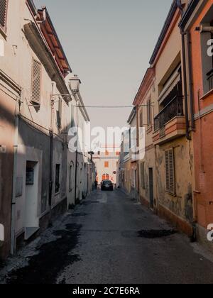 Vertikale Aufnahme einer leeren Gasse in der Mitte von Gebäude und ein Auto in der Ferne geparkt Stockfoto