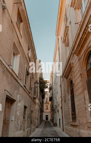 Vertikale Aufnahme einer Gasse in der Mitte von Gebäuden Unter blauem Himmel am Tag Stockfoto
