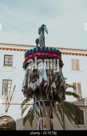 Vertikale Aufnahme einer Statue mit Dekorationen vor Ein Gebäude unter dem schönen Himmel Stockfoto