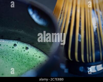 Hellgrüner Matcha-Tee mit Schneebesen im Hintergrund Stockfoto