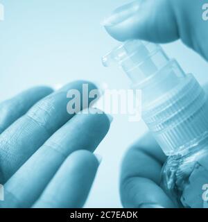 Weibliche Hand verwenden Desinfektionsmittel Gel aus einer kleinen Plastikflasche Stockfoto