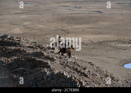 Kasachische Nomaden auf der Jagd mit Steinadlern im Altai-Gebirge der westlichen Mongolei. Stockfoto