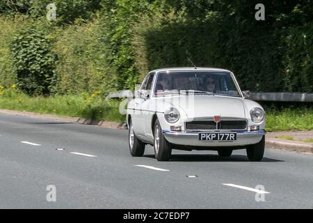 1976 weiße MG B GT Fahren auf der Autobahn M6 bei Preston in Lancashire, Großbritannien Stockfoto