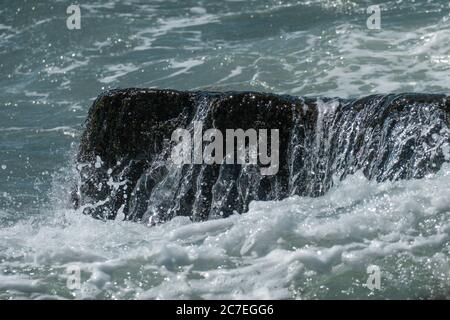 Wasser spritzt über einem Felsen im atlantik und schafft ein schönes Bild Stockfoto