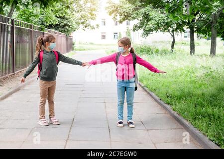 Soziale Distanz im Schulkonzept. Schulkinder in Schutzmasken zeigen sozialen Abstand von 6 Fuß. Zurück zur Schule während der Coronavirus-Pandemie Stockfoto