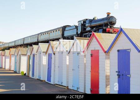 Zug vorbei an bunten Strandhütten in South Devon, Großbritannien Stockfoto