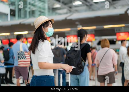 Asiatische Frau Reisende mit Maske mit Pass beim Kunden Check-in der Airline Service Schalter, wenn sie mit dem Flugzeug Transport für neue n reisen Stockfoto