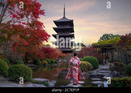 Junge japanische Mädchen Reisende in traditionellem Kiminokleid im Toji-Tempel mit Holzpagode und rotem Ahorn-Blatt in der Herbstsaison in Kyoto, Jap Stockfoto