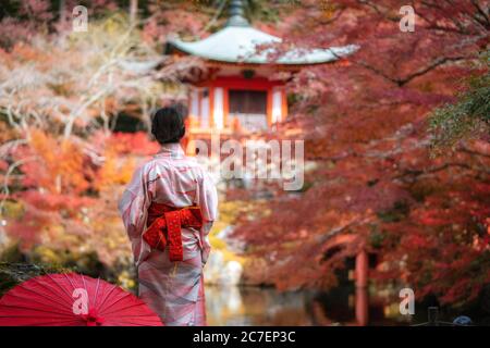 Junge japanische Mädchen Reisende im traditionellen Kiminokleid im Digoji-Tempel mit roter Pagode und rotem Ahorn-Blatt in der Herbstsaison in Kyoto, Japan Stockfoto