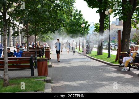 Kühlsystem auf der Straße Khreschatyk, Sprühen einen kalten Dampf. Leute, die die Straße hinunter gehen. Stockfoto