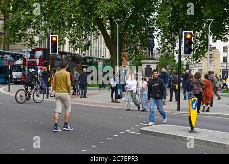 Die Menschen überqueren die Straße vor der Statue "EINE Woge der Macht (Jen Reid)", die auf dem Sockel steht, der von Colstons Statue in Bristol, Großbritannien, besetzt ist Stockfoto