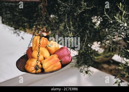 Nahaufnahme von orangen und roten Paprika auf einem Alte Waage mit unscharfem Hintergrund Stockfoto