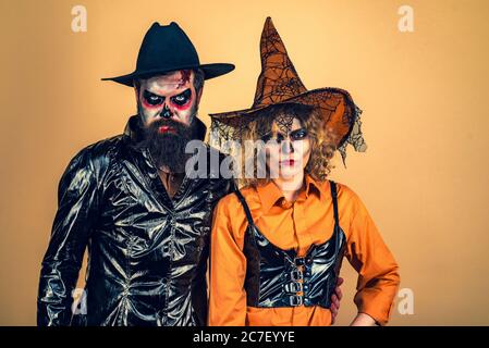 Schöne überrascht Frau in Hexenhut und Kostüm - Produkte zeigen. Halloween überrascht Frau und schönen bärtigen Mann in Halloween Hut und Kostüm Stockfoto