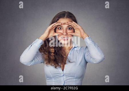 Closeup Portrait, Kopfschuss junge Frau, spähen durch die Finger wie Fernglas überrascht, schockiert suchen etwas Blick in zukünftige isolierte gr Stockfoto