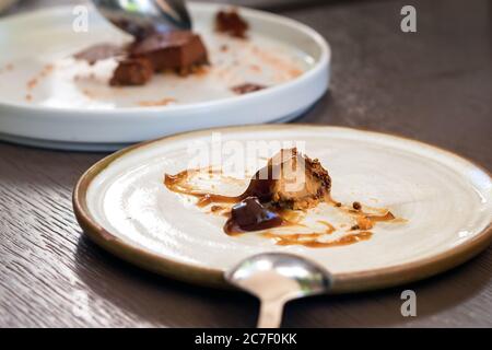 Ein Teller mit einem Feinschmeckerdessert, der auf einem Tisch übrig ist Stockfoto