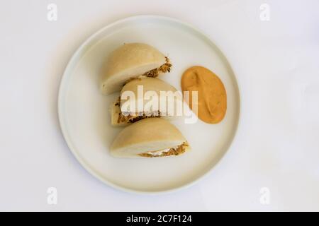 Gedämpfte Brötchen mit Schweinebäcken und Orangensoße. Gourmet-Gericht auf einem Tisch Stockfoto