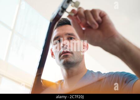 Mann Tuning Seine Akustische Gitarre Vor Dem Spielen Von Musik Stockfoto