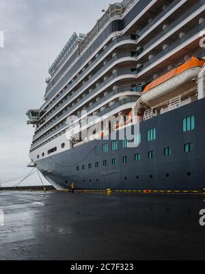 Vertikale Low-Angle-Aufnahme eines riesigen Kreuzfahrtschiffes mit Liegeplätzen In Island unter dem klaren Himmel Stockfoto