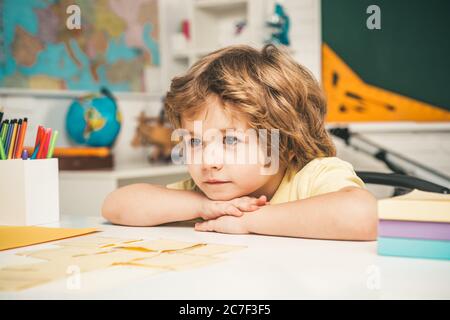 Beginn der Unterrichtsstunden. Kinder machen sich bereit für die Schule. Happy cute fleißig Kind sitzt an einem Schreibtisch drinnen. Stockfoto