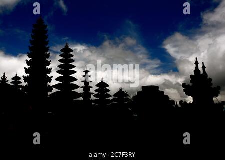 Horizontale Silhouette von Tempelstupas in Bali, Indonesien unter dem atemberaubenden bewölkten Himmel Stockfoto